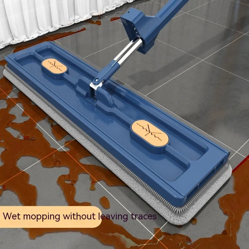 Large flat mop with long stainless steel handle, blue rotating head, and integrated scraper on a hardwood floor.