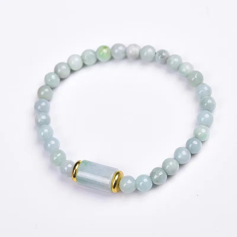 Close-up of a geometric jade bracelet with round emerald-coloured beads on a wrist.