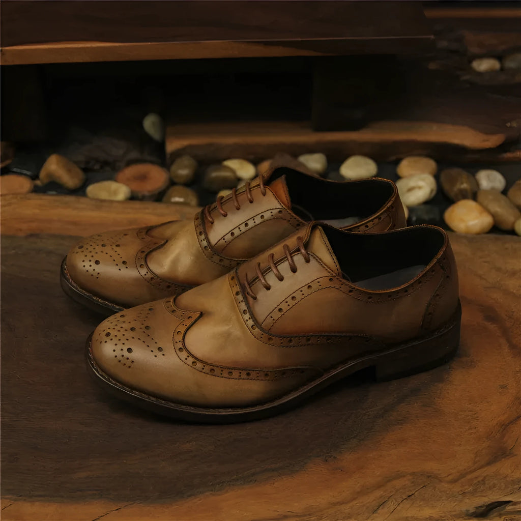 Men's light brown vintage distressed leather shoes with carved detail and round toe.