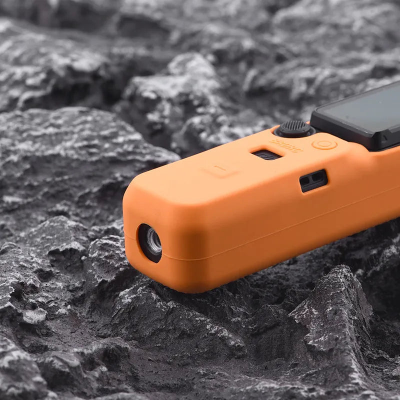 Silicone protective cover for camera body in black, red, and orange colours showing non-slip texture