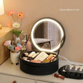 Round pink LED makeup bag open showing internal partitions and illuminated mirror.