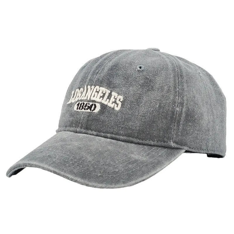 Personalised retro-style peaked cap with embroidered letters on distressed fabric in beige colour.