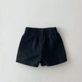 Baby loose thin cotton and linen shorts in black with elastic waist, side view on white background