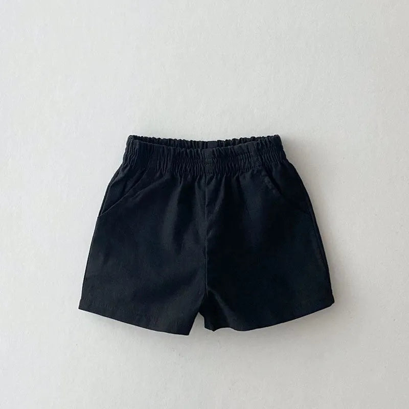 Baby loose thin cotton and linen shorts in black with elastic waist, side view on white background