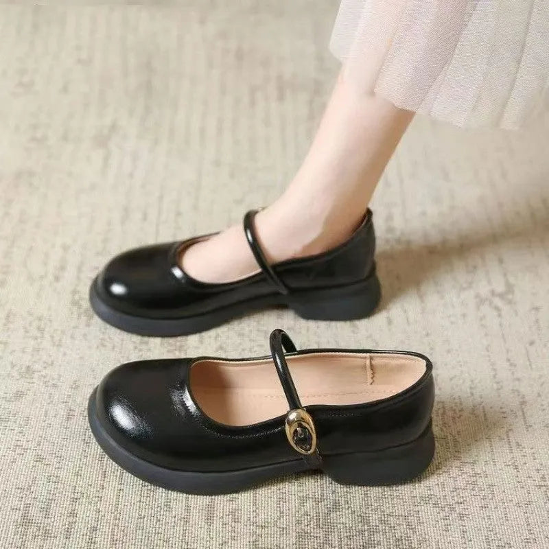 Flat black cheongsam leather shoes with a white skull pattern on the toe and a light brown wedge heel.