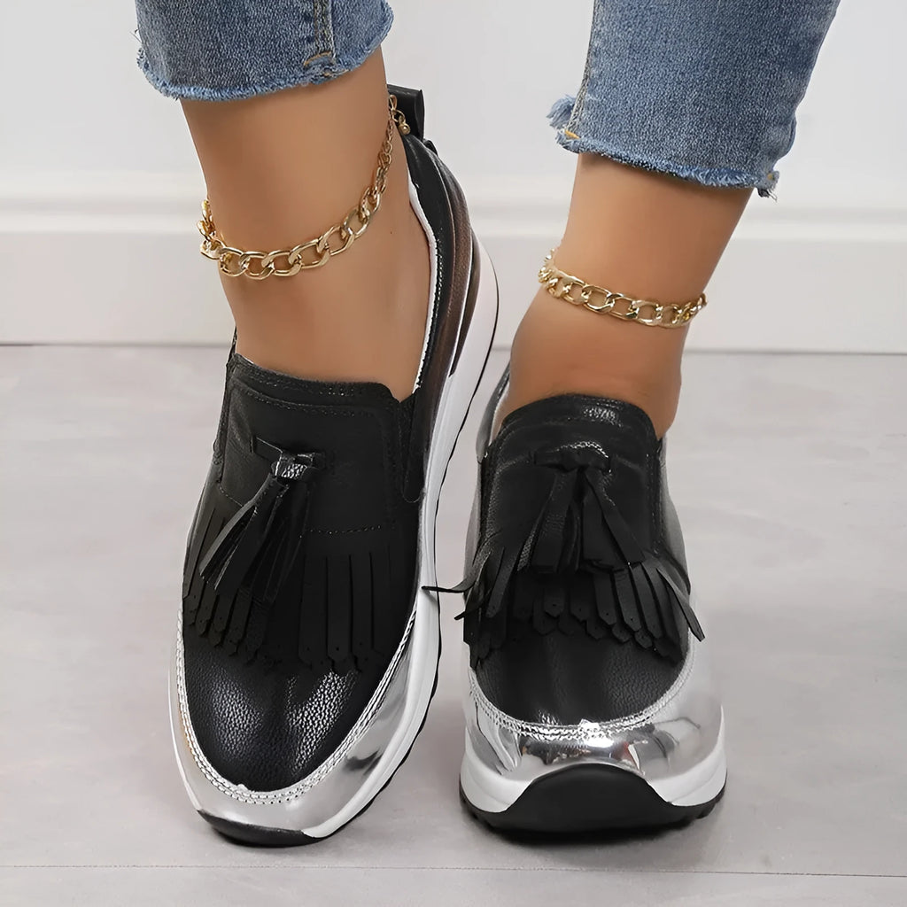 Black women's casual platform shoes with tassel detail and a distinctive English muffin wedge heel.