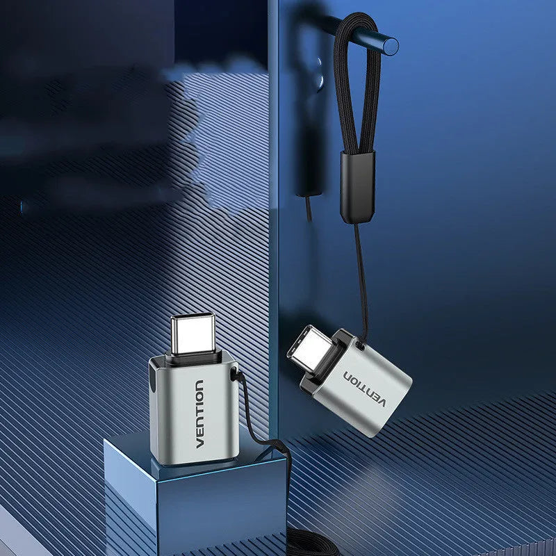 Grey aluminium alloy USB-C male to USB-A female OTG adapter with a black lanyard attached.
