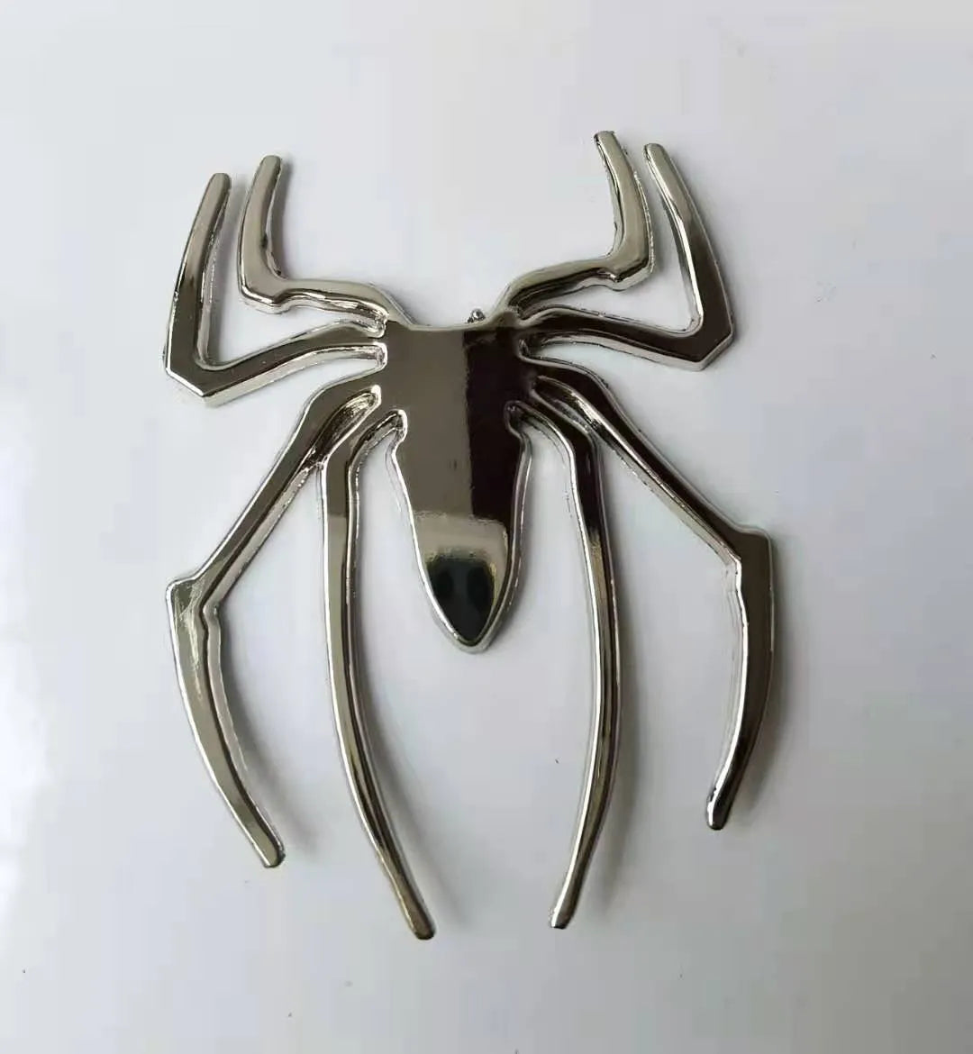 Three-dimensional metal spider bumper sticker in metallic finish.