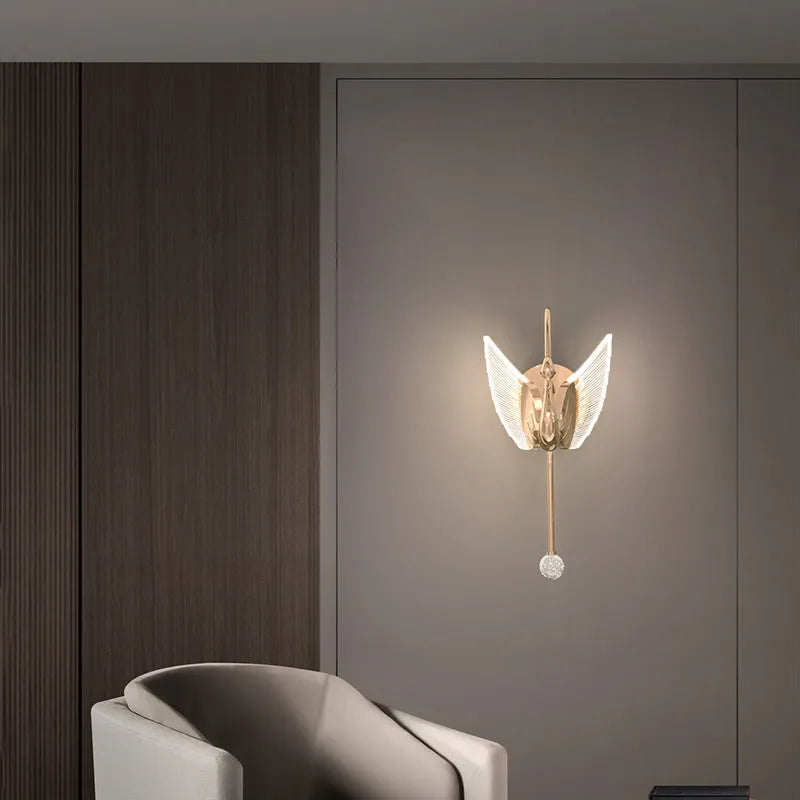Modern minimalist gold swan-shaped wall lamp with an acrylic shade and LED light.