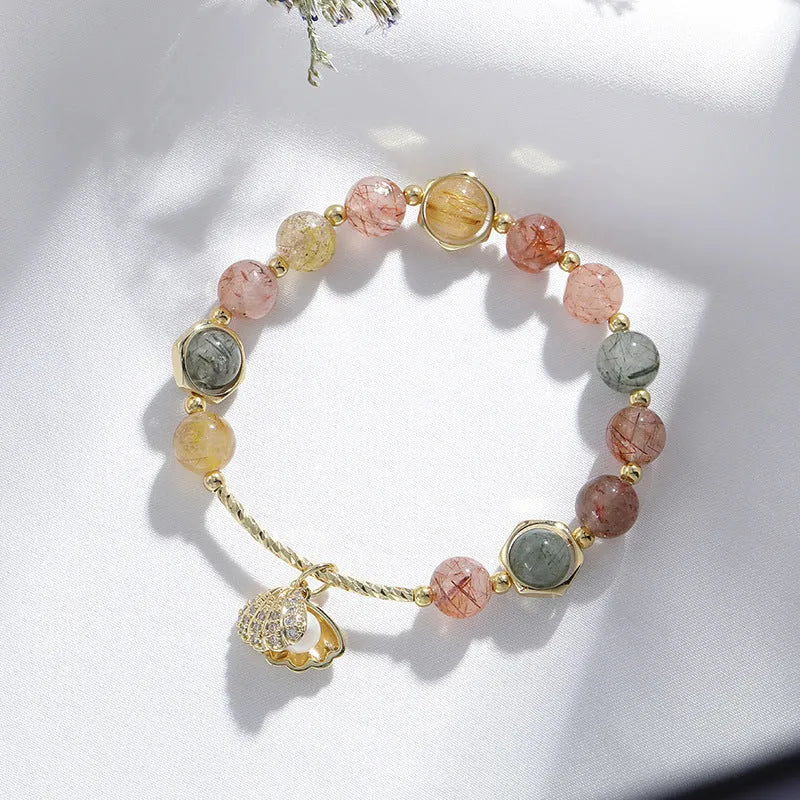 A women's crystal bracelet with colourful hair crystal shells and a red sealant flower shell on an electroplated band.