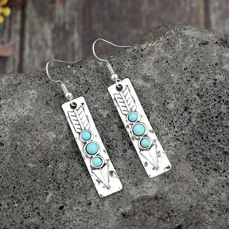 Long silver geometric drop earrings with inlaid turquoise details on a retro-style zinc alloy setting.