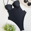 A black one-piece swimsuit for women made from spandex, laid flat.