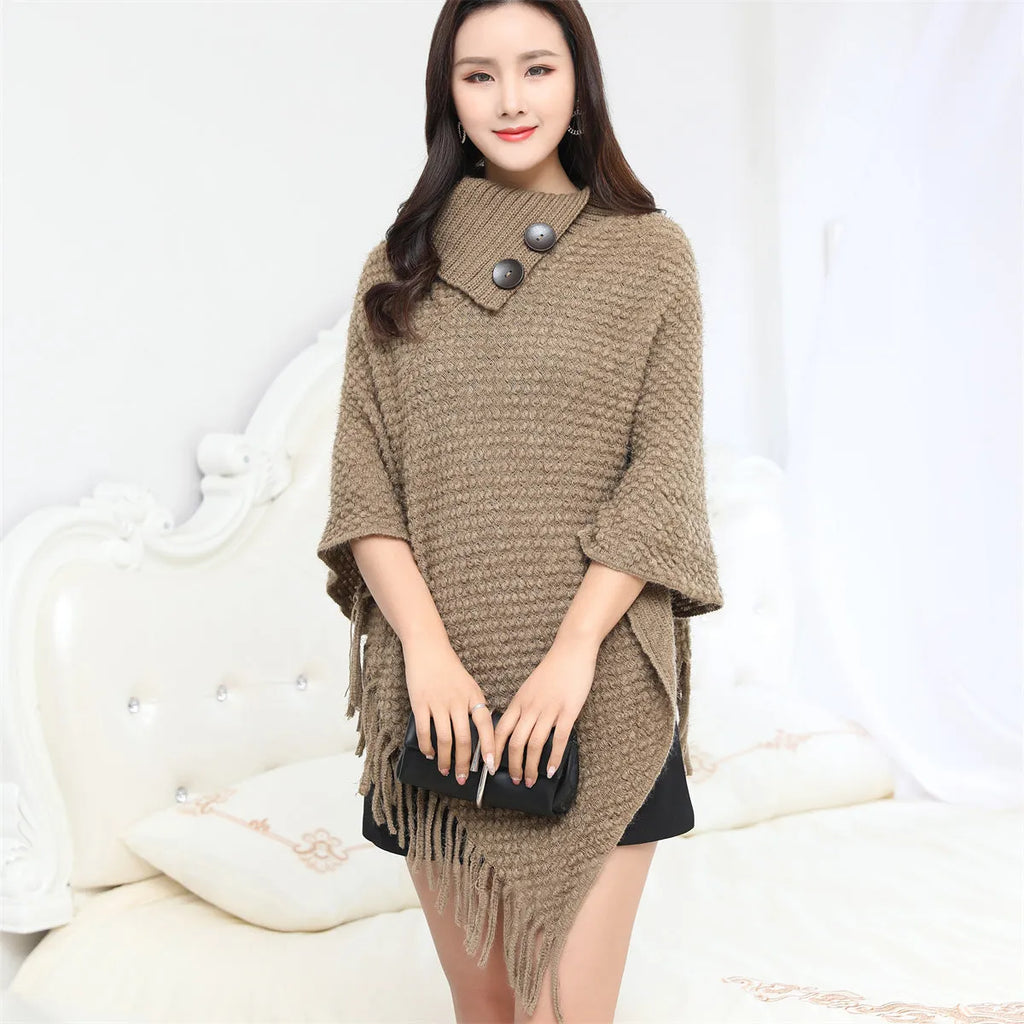 Sleeveless dot pattern knit cloak poncho in apricot colour, laid flat.