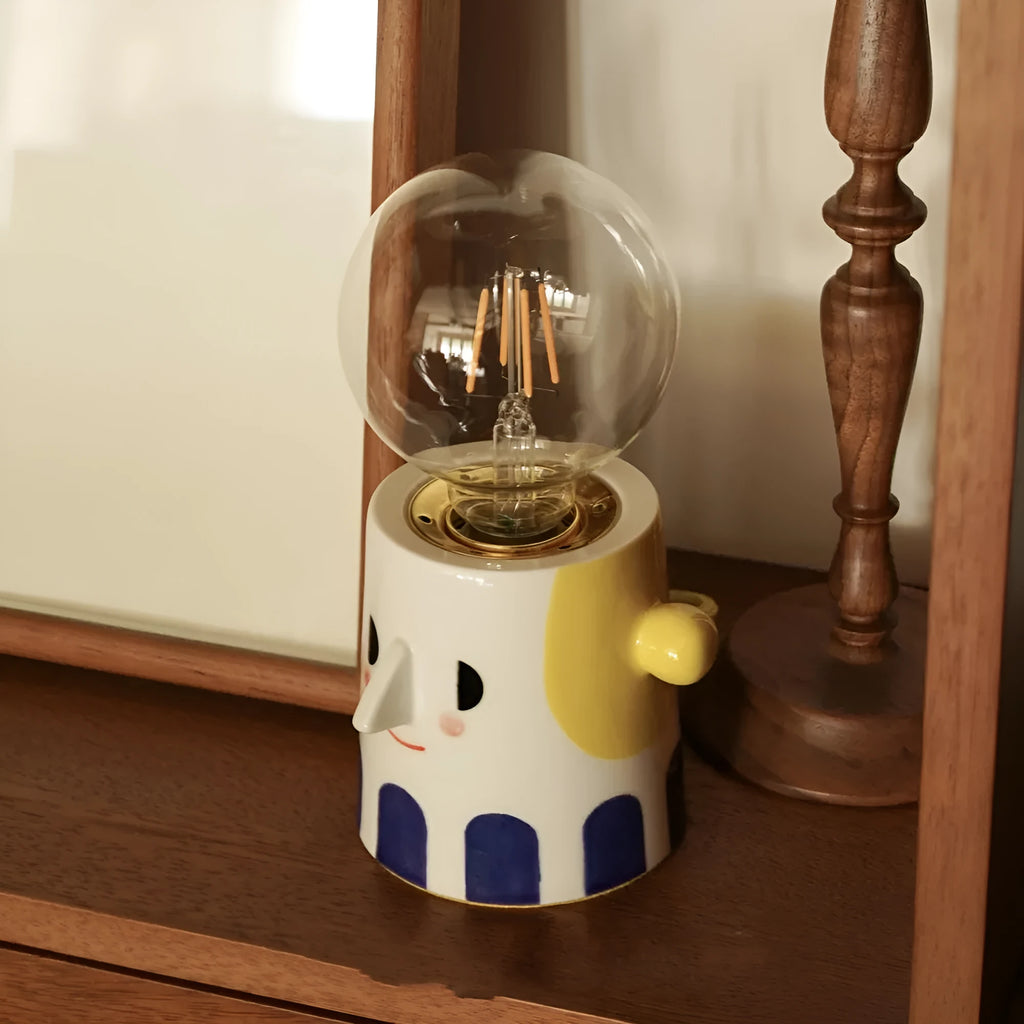 Handmade ceramic bedside lamp with a creative ball headlight design on a wooden table.
