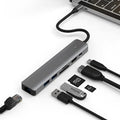 Silver aluminium 7-in-1 USB-C hub with SD card slot, microSD slot, USB-A, and USB-C ports.