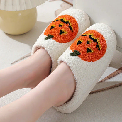 Cozy Halloween-themed pumpkin slippers in white and black colors, featuring soft suede uppers and durable rubber soles for indoor wear