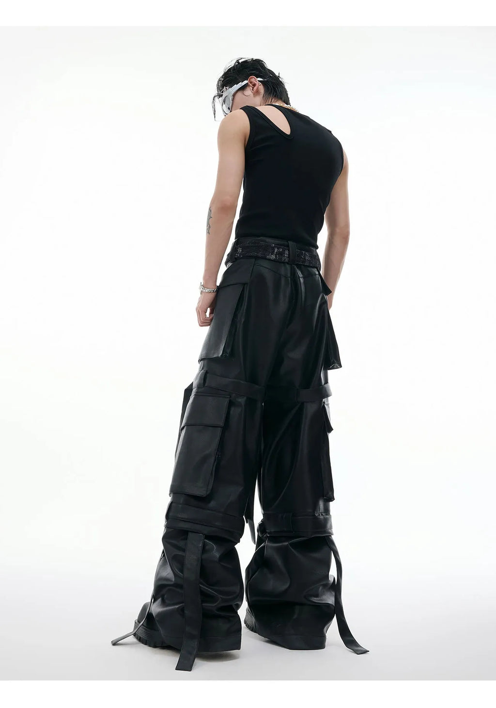 Black loose-fit leather-look trousers with multiple pockets, quilted panels, and ribbon trim details.