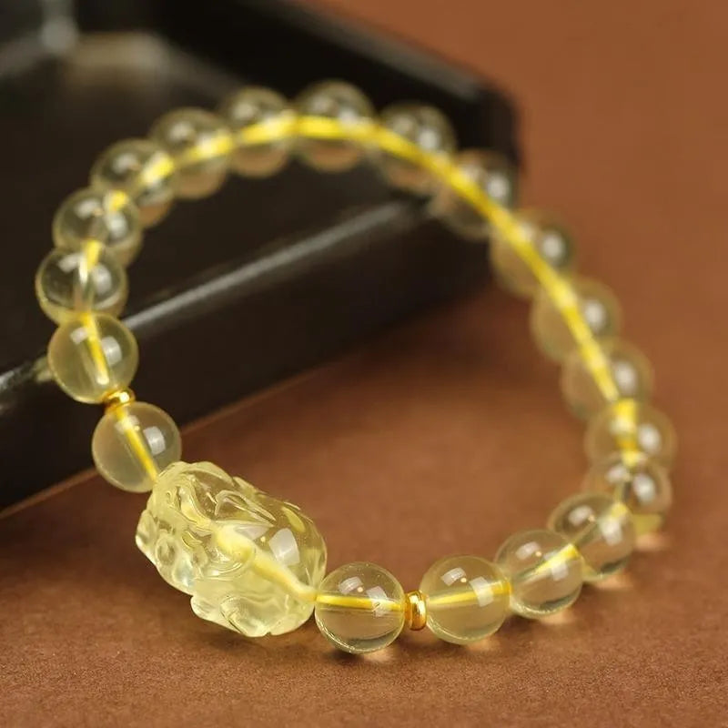 Yellow Pi Xiu bracelet with artificial crystal beads on an adjustable leather strap.