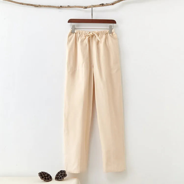 Men's solid colour cotton casual trousers with belt in beige, showing mid waist and drawstring design