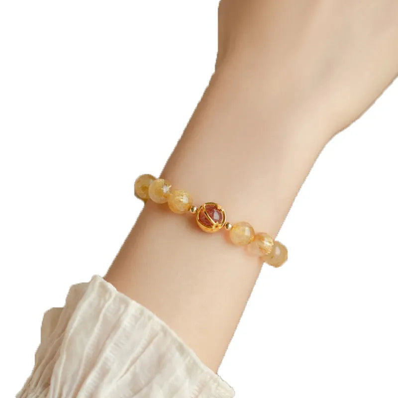 Gold rutilated quartz crystal bracelet with diamond-shaped links and natural citrine beads
