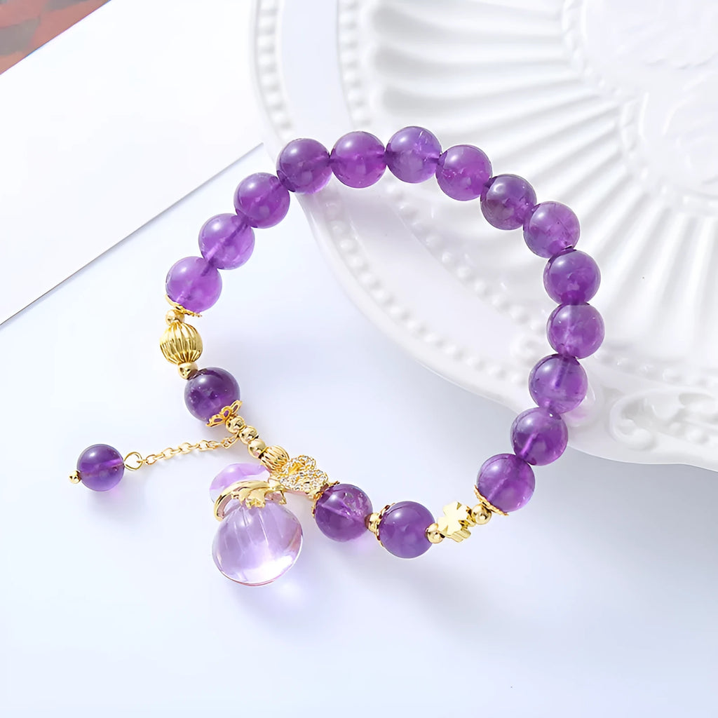 Purple amethyst bracelet with ethnic money bag pendant and peace buckle closure on wrist