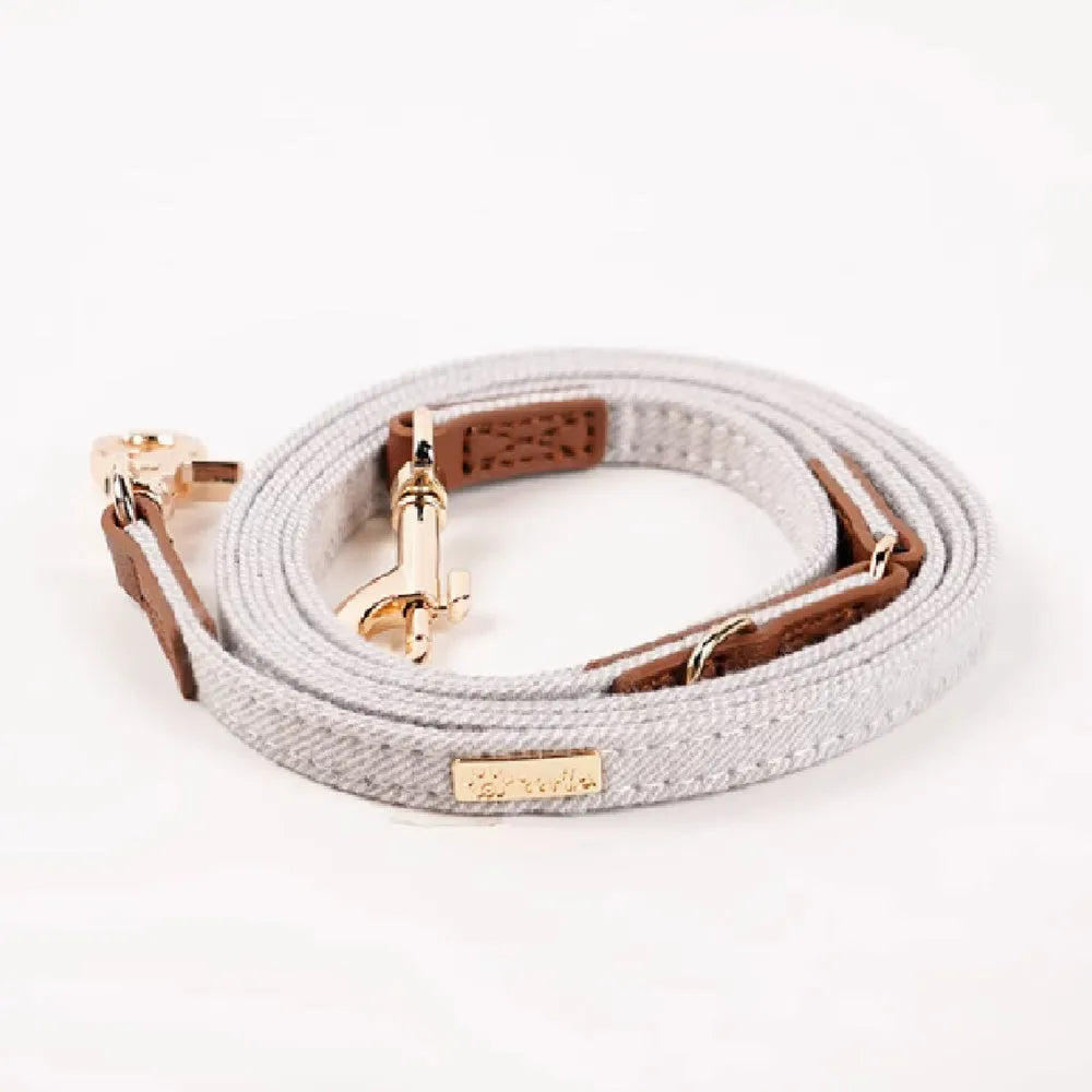 Adjustable mohair dog collar with nameplate and hand holding rope in cement gray