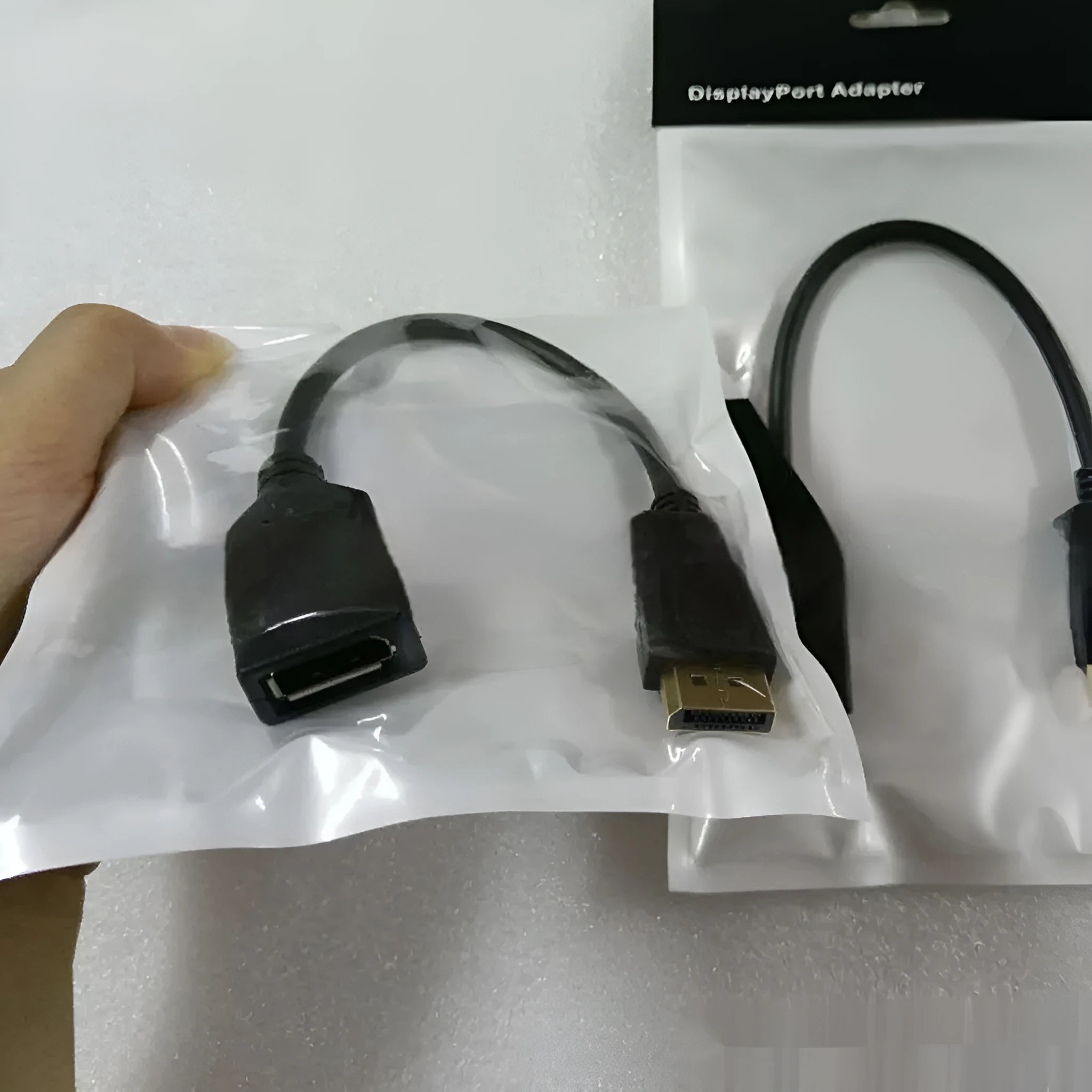 Black DisplayPort male to female extension cable with rotating busbar, approximately 10cm long