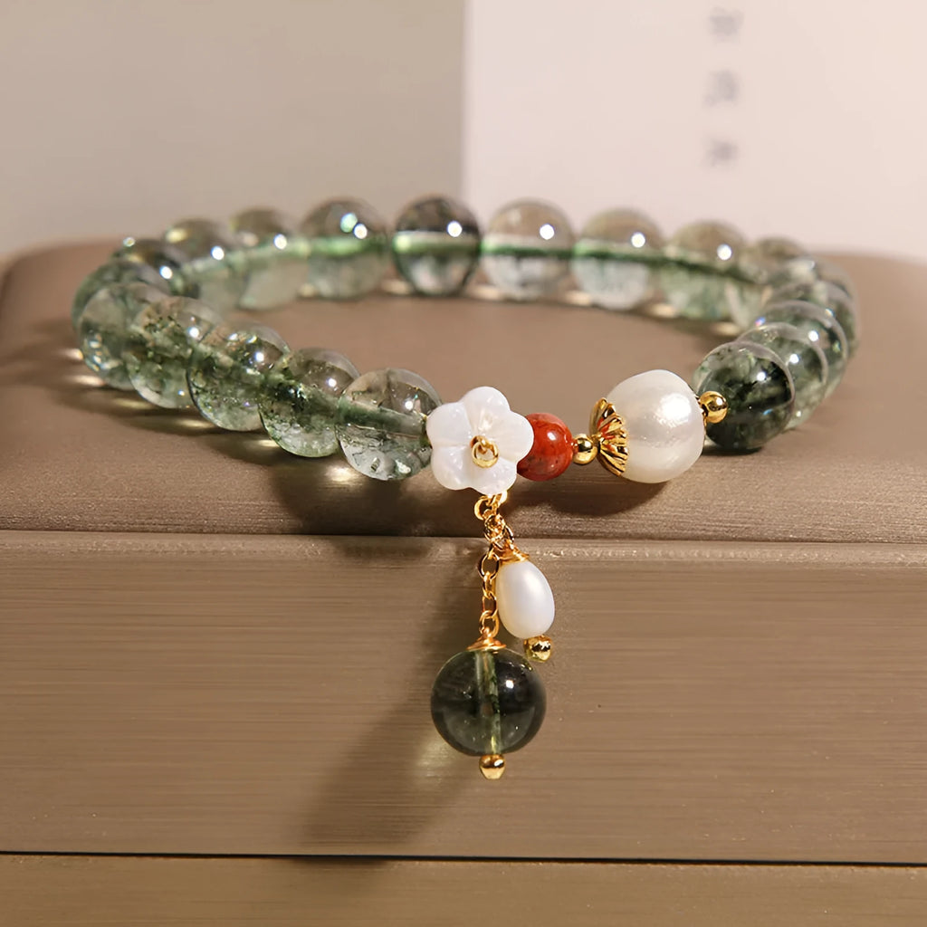Green phantom quartz crystal bracelet for women with a small white shell flower accent.