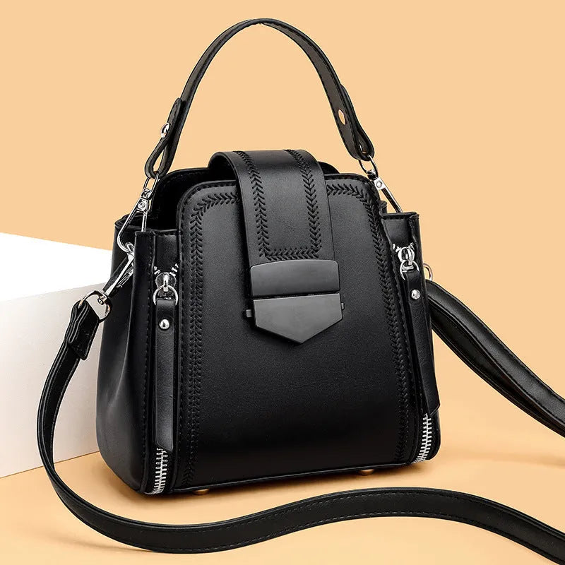 Soft black PU leather square vertical ladies handbag with textured stitching.