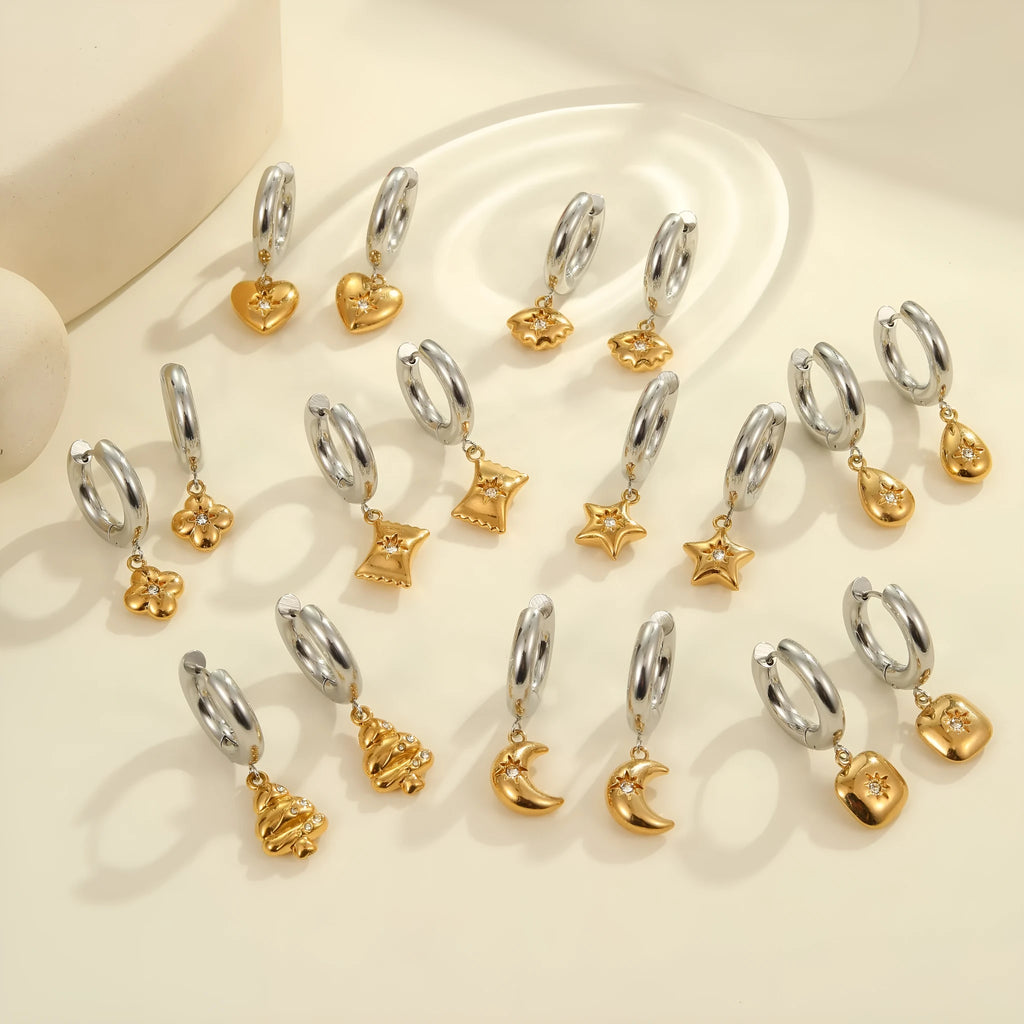 A pair of stainless steel earrings with 18K gold plating in a Christmas tree and heart shape design.