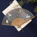 Bamboo folding fan with silk embroidery showing traditional Chinese patterns