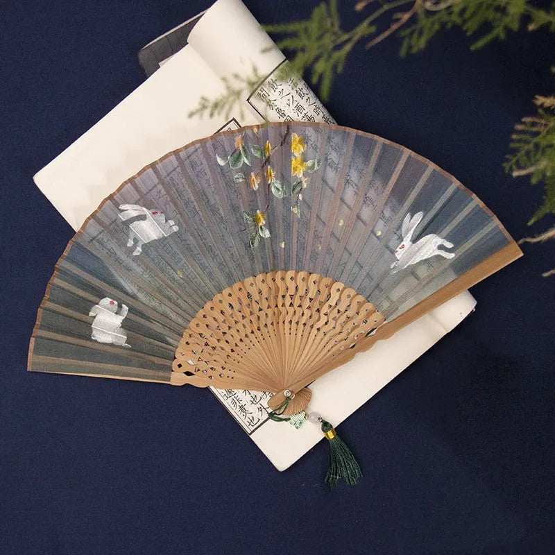 Bamboo folding fan with silk embroidery showing traditional Chinese patterns