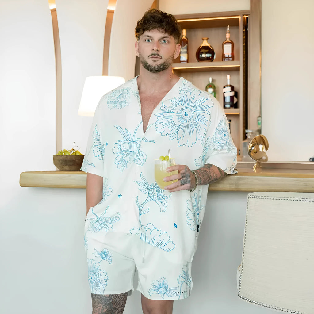 Man wearing a loose-fitting grey short-sleeve top with a floral print design.
