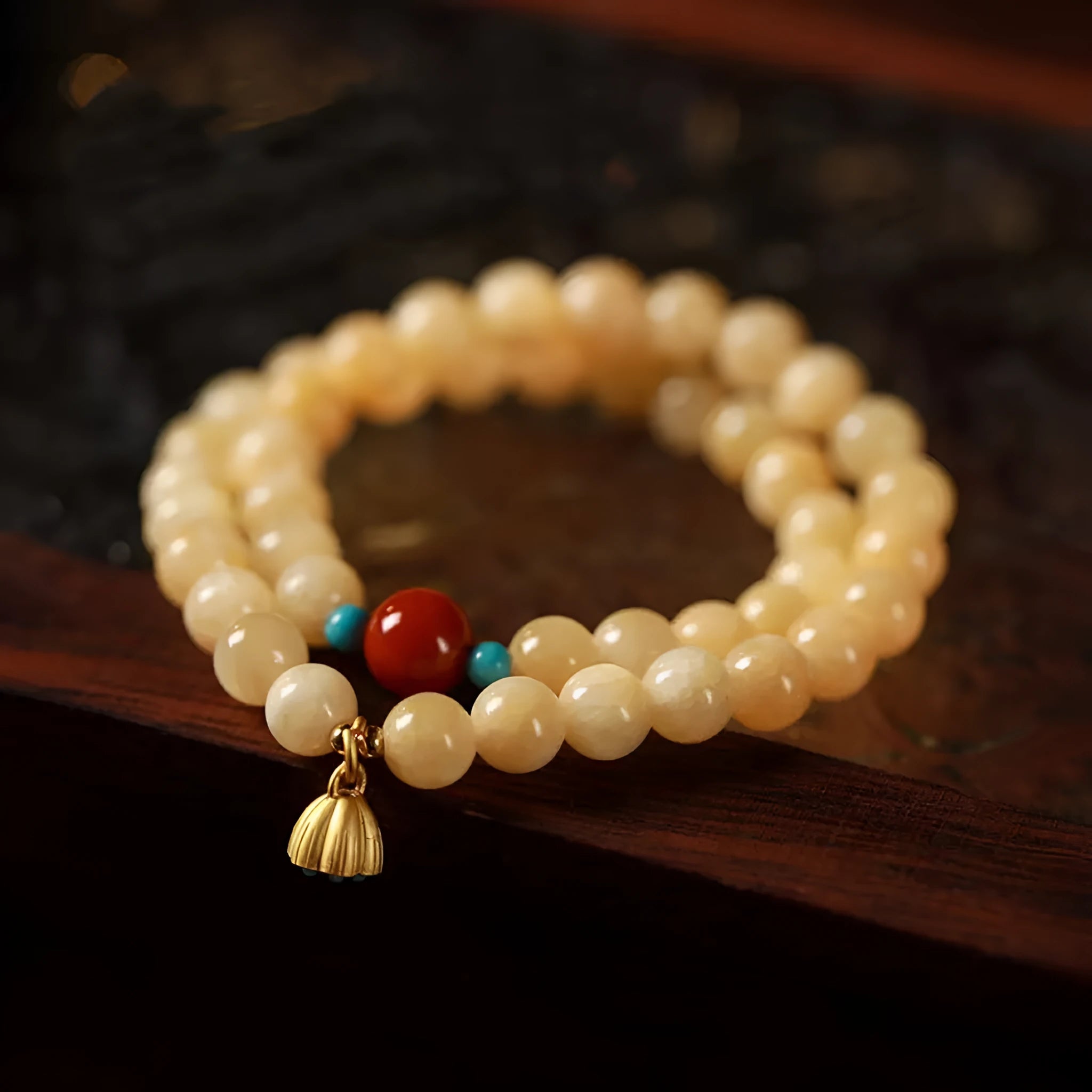 Yellow jade double ring bracelet with topaz lotus seedpod design on white background