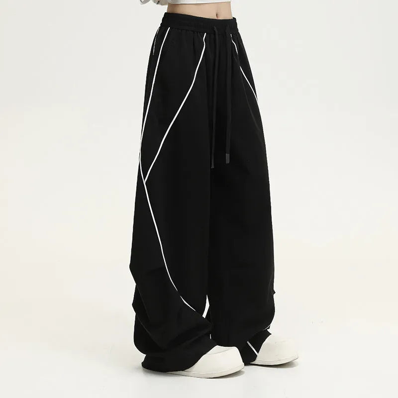 Black striped pleated wide-leg hip hop trousers on hanger showing mid-waist design