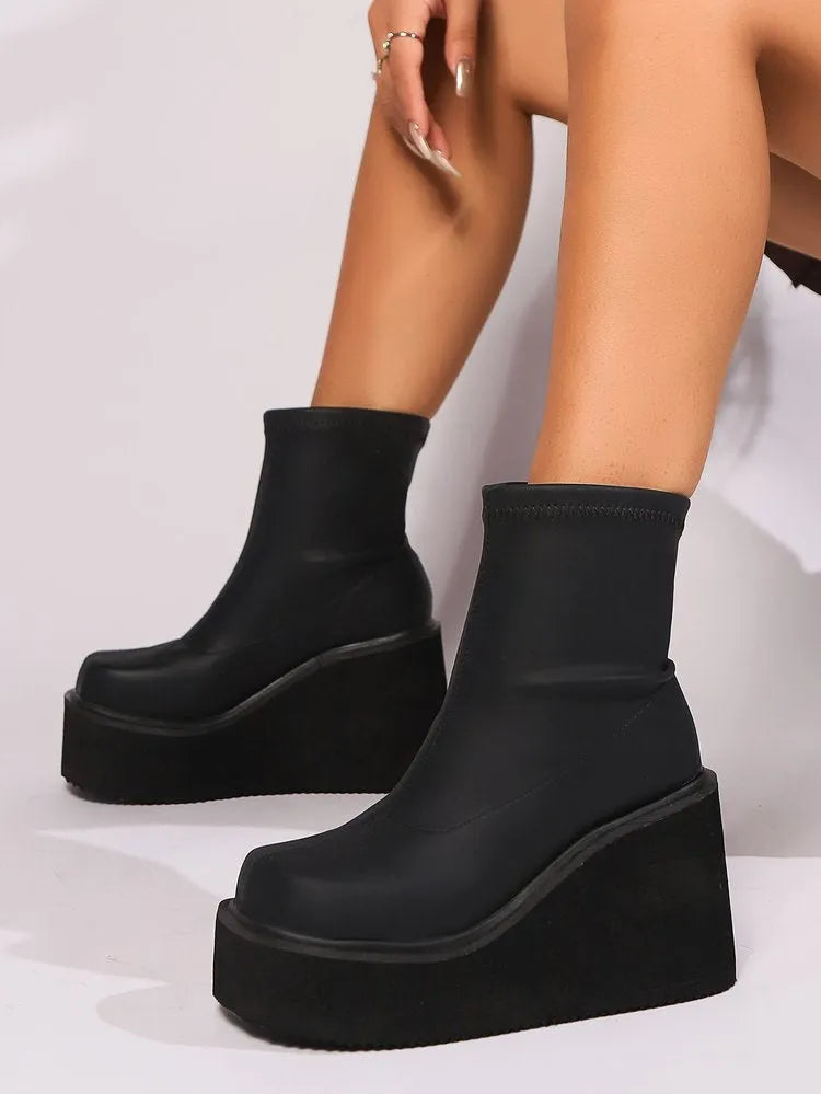 Plus size women's black wedge heel ankle boots with a waterproof platform and round toe.