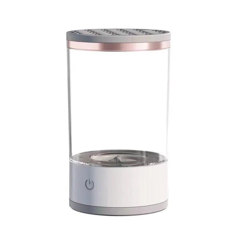 Grey and white electric makeup brush cleaner with USB charging cable on a wooden surface