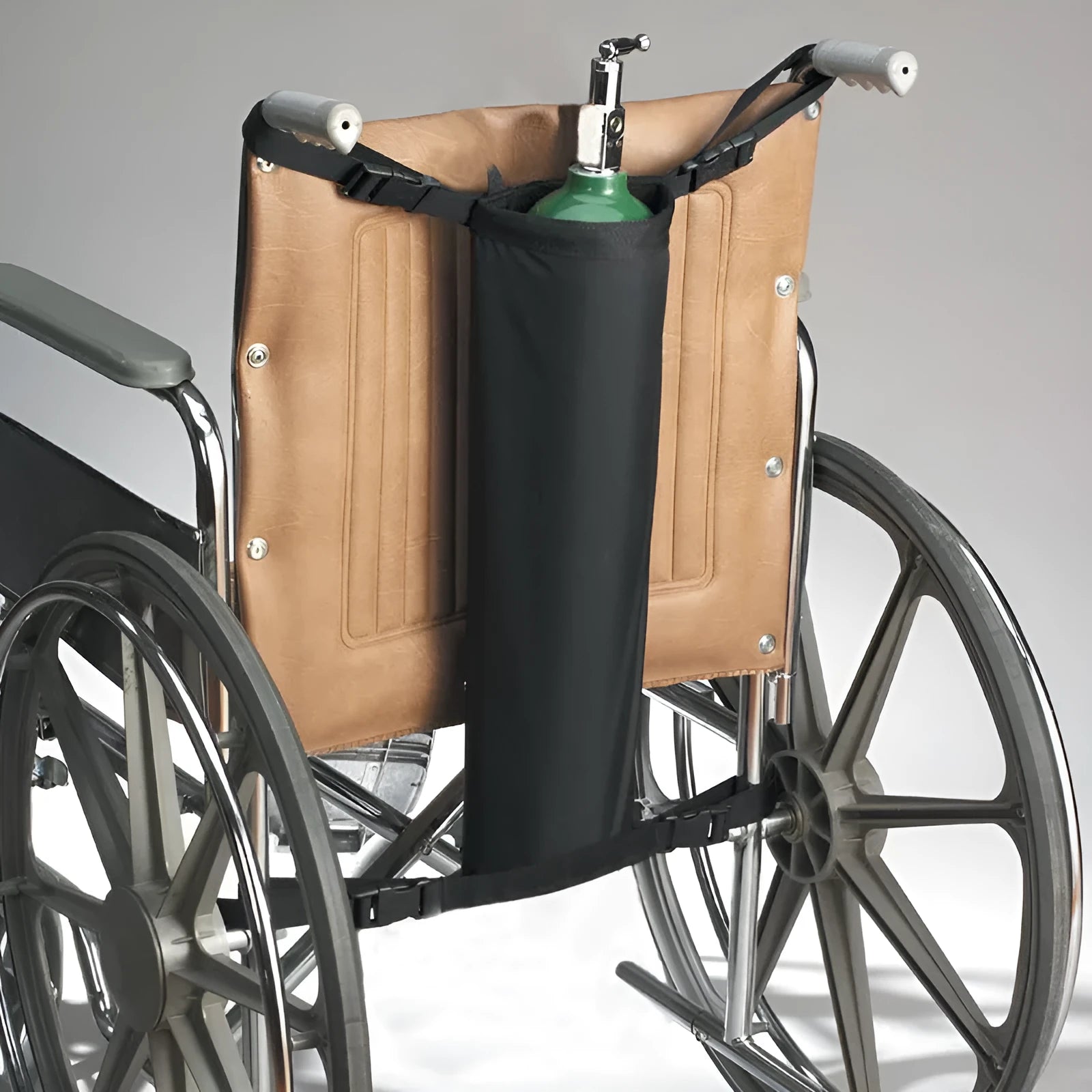 Black cylindrical Oxford cloth pannier bag attached to a wheelchair for oxygen cylinder carriage.