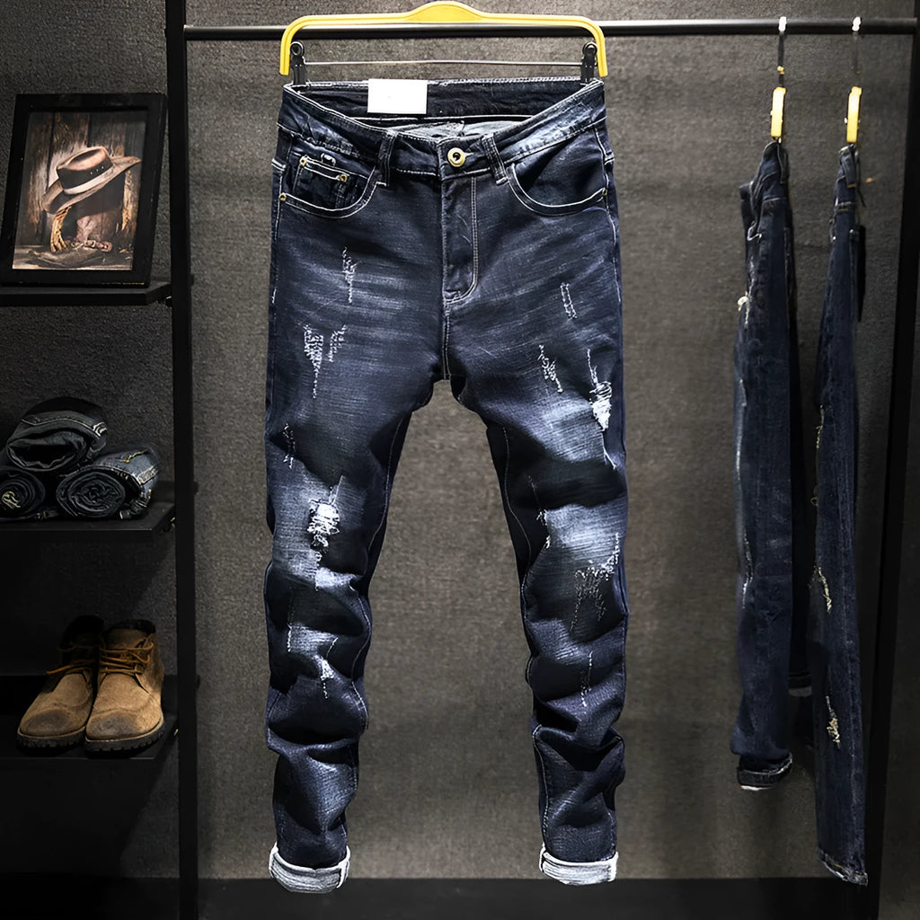 Men's slim-fit dark blue cotton denim jeans with a mid-waist and ankle-length leg.