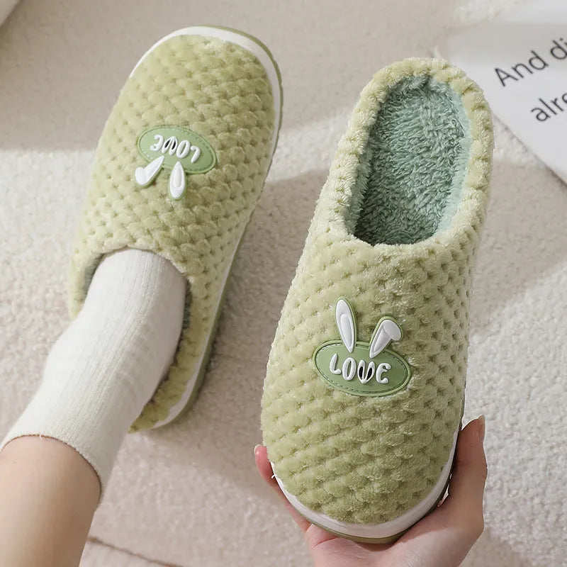Rabbit plaid design artificial fur house slippers with a non-slip rubber sole.