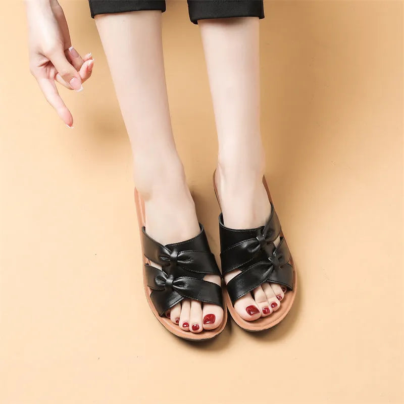 Women's beige cowhide slippers with a soft sole, shown from the side.