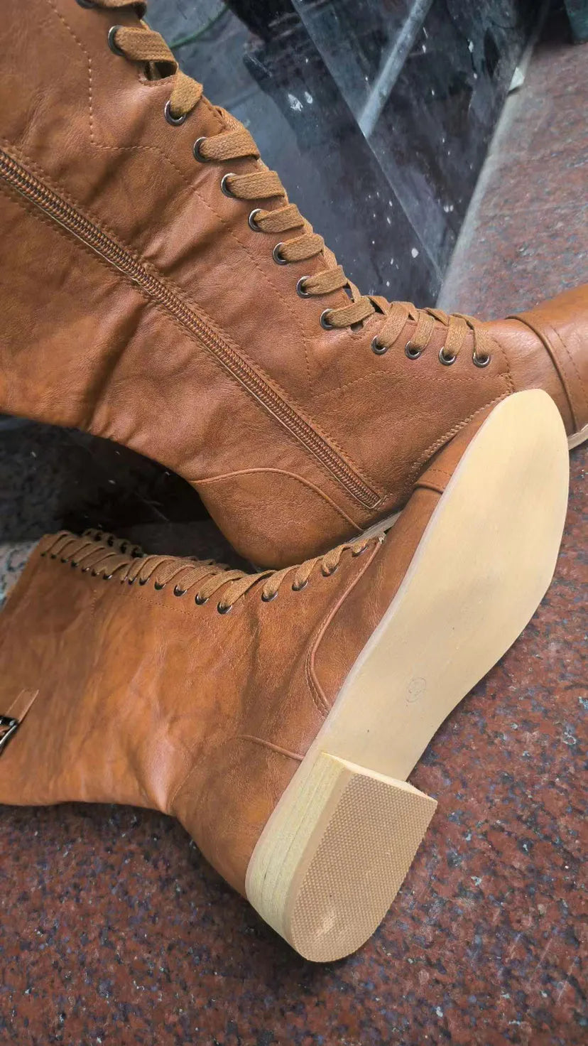 Women's black knee-high knight boots with a cross strap detail across the ankle.