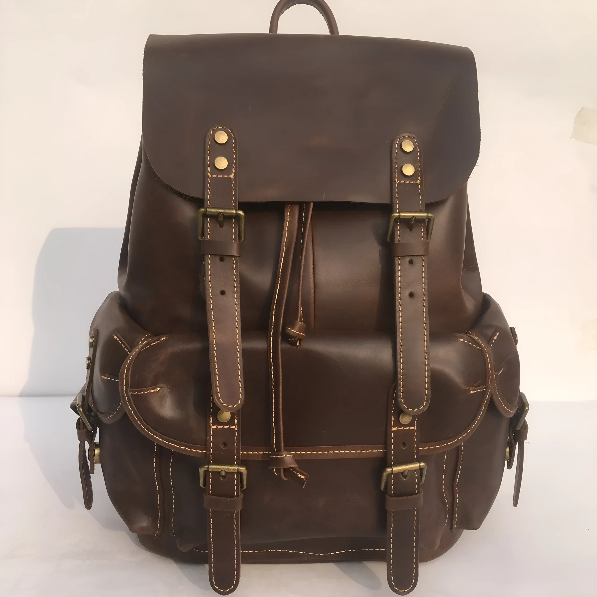 Brown men's leather backpack with an air pillow belt on the straps.