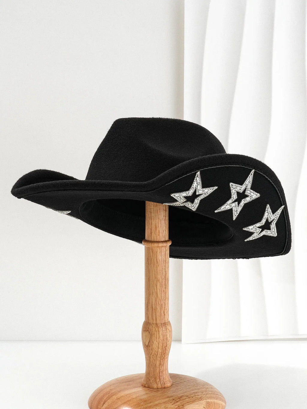 Beige woolen felt Western-style top hat with a conical crown and a silver hexagonal star decoration on the front.