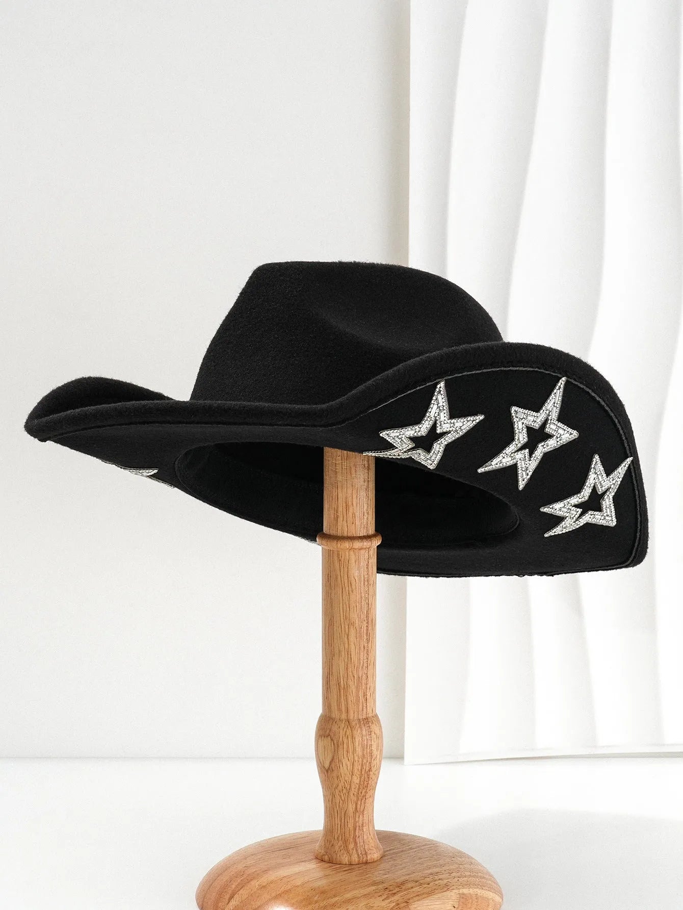 Beige woolen felt Western-style top hat with a conical crown and a silver hexagonal star decoration on the front.