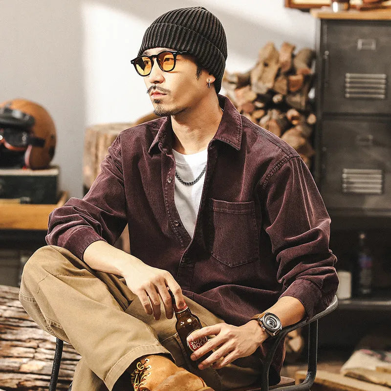Men's red corduroy loose-fit shirt jacket with long sleeves on a hanger.