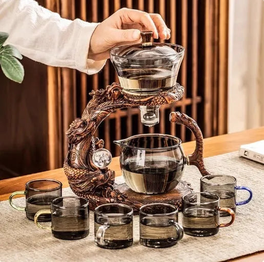 Green gray walnut glass automatic tea set with bowl, base, and fair cup on a table