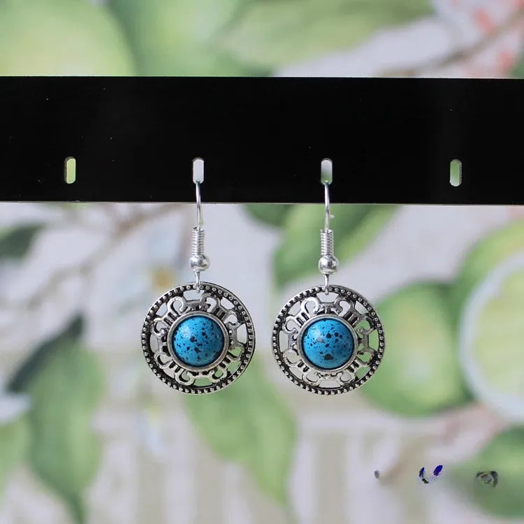 Handmade geometric flower disk earrings in Tibetan silver and turquoise with ethnic patterns.