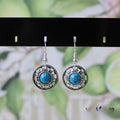 Handmade geometric flower disk earrings in Tibetan silver and turquoise with ethnic patterns.