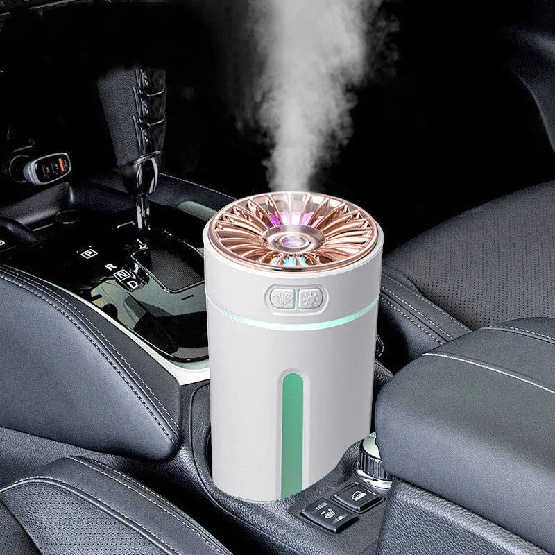 Compact black wireless USB humidifier with colourful LED lights on a car cup holder.